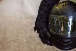 Motorcycle Guy In Raiders Clothes, Gearing Up. A Young Men Stands Near An Motorcycle In Nature Durin